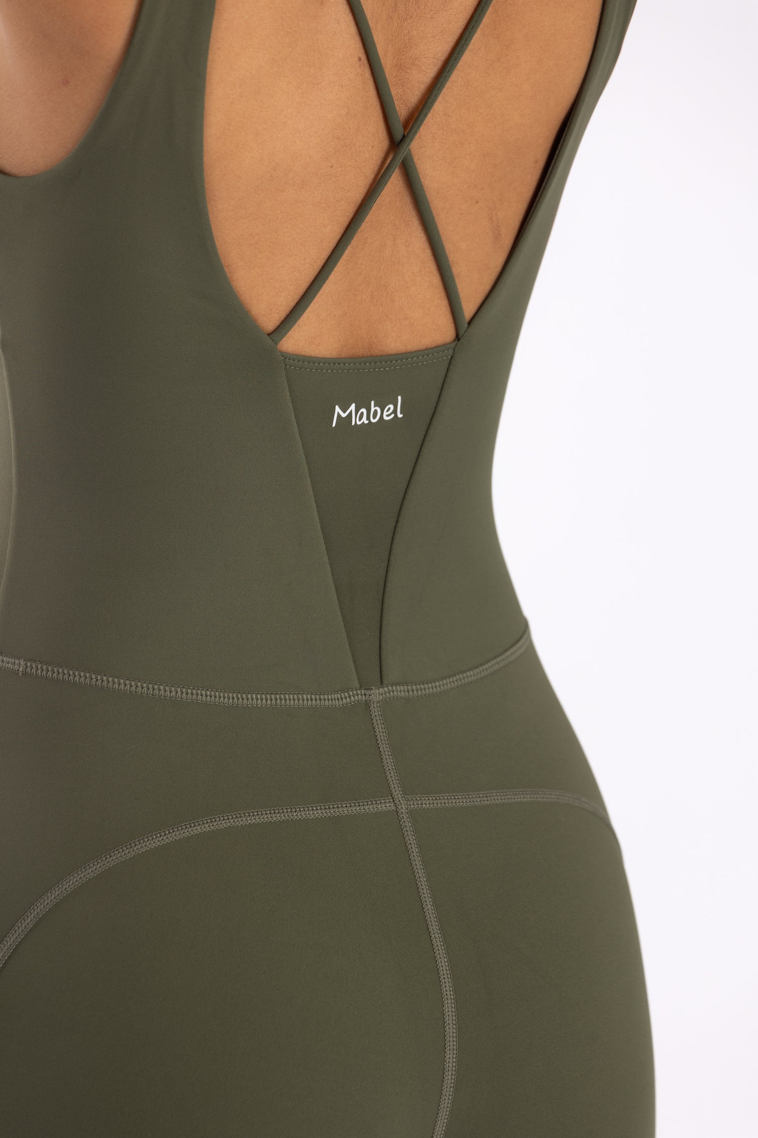 woman wearing a green jumpsuit on a white background. אוברול ירוק זית לפילאטיס ויוגה